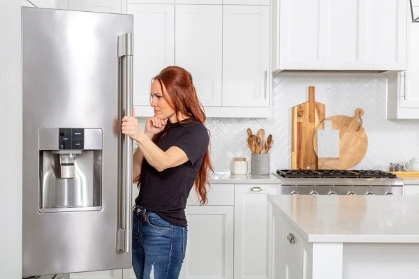 woman infront of noisy fridge