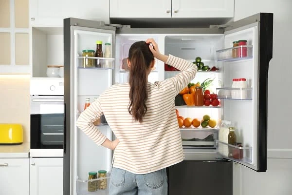 woman pinpointing noise of fridge