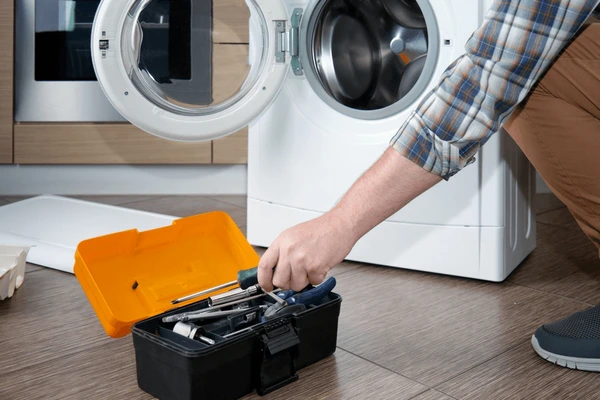 Man with tools in the washer in Orillia